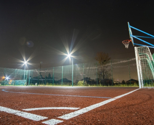 Image of an outside basketball court at night.