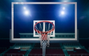 Front view of arena lights shining through a glass basketball hoop backboard